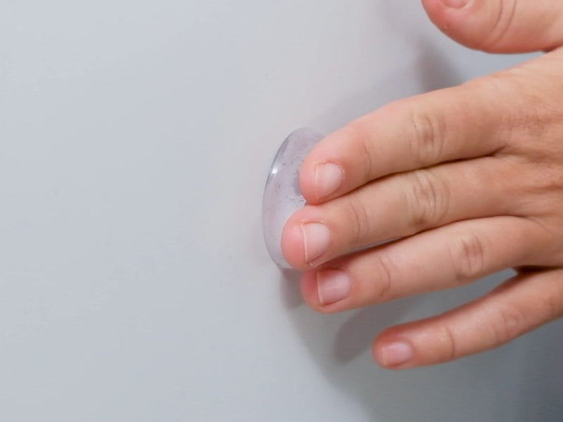 Palm pressing a clear protector onto the wall